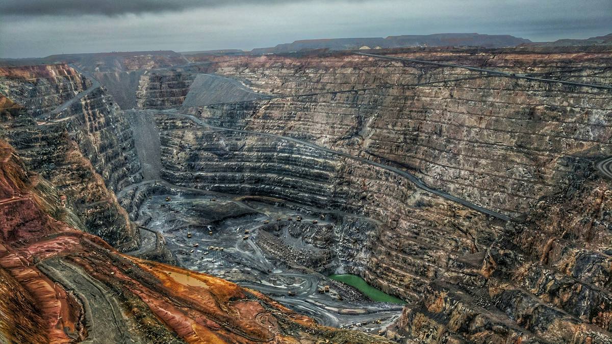 A huge open-pit mine, with terraced walls cut deep into red rock
